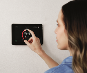 Woman moving the temperature on a thermostat