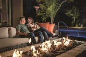 Man and woman sitting by an outdoor fire pit