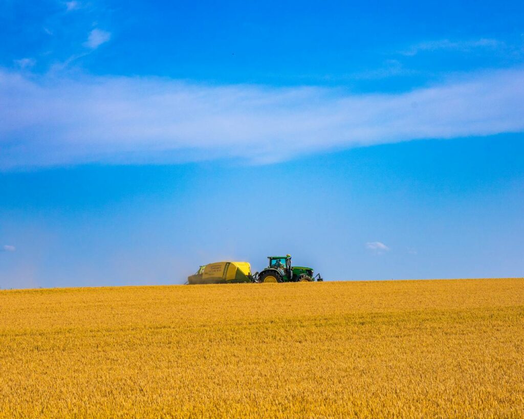 Farmer on their tractor harvesting plants for biofuel heating