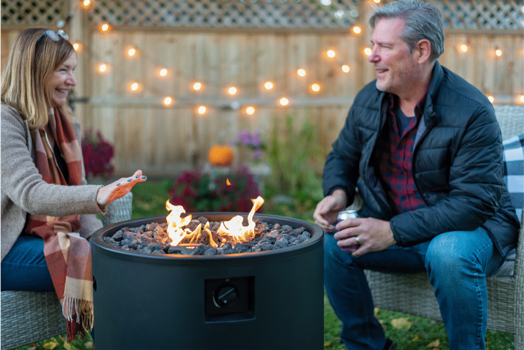 Middleage couple sitting by backyard prpane firepit